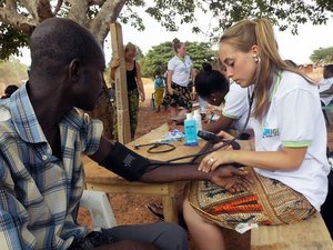 weltwaerts Freiwilligendienst in Ghana-Freiwillige untersucht Mann im Gesundheitsprojekt IGI